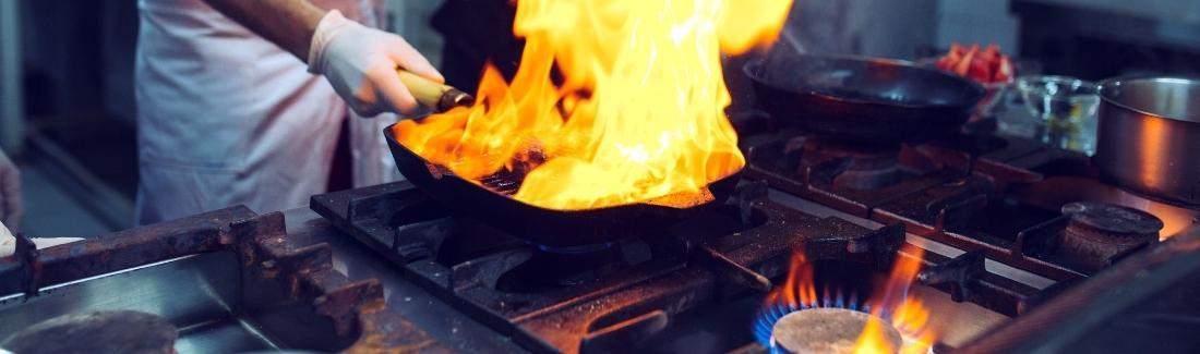 Person frying food over gas hob
